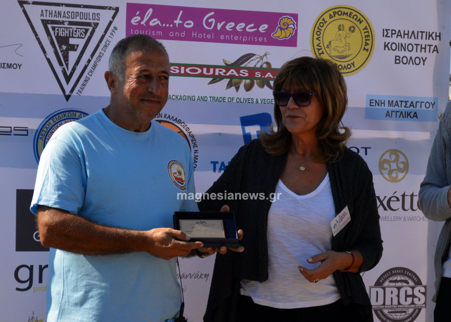 Ο υπεύθυνος εθελοντών της Λέσχης Ειδικών Δυνάμεων Βασίλης Ηλιόπουλος, παραλαμβάνει τιμητική πλακέτα για τη συνδρομή του συλλόγου στη διοργάνωση του φιλανθρωπικού αγώνα, από την πρόεδρο της "Φλόγας" κα Ντίνα Τριανταφύλλου. 