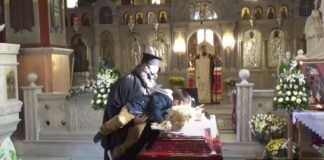Ιερέας σηκώνει παιδάκι να φιλήσει τη σορό του Μητροπολίτη Λαγκαδά που πέθανε από κορωνοϊό