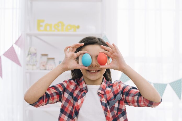 smiling-girl-holding-red-blue-easter-eggs-her-eyes-home