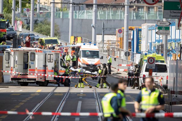 An unidentified man is pushed on a stretcher as paramedics bring him to an ambulance in Zurich