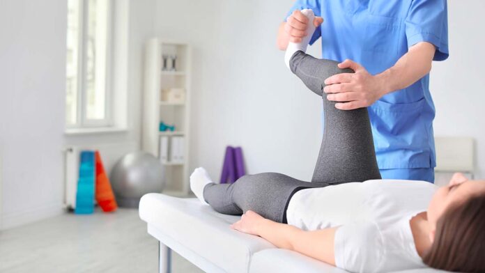 Physiotherapist working with female patient in clinic