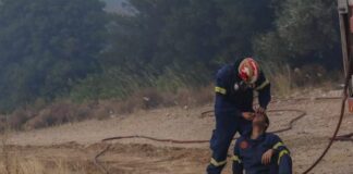 Πυροσβέστης δίνει τις πρώτες βοήθειες στον συνάδελφό του την ώρα της μάχης