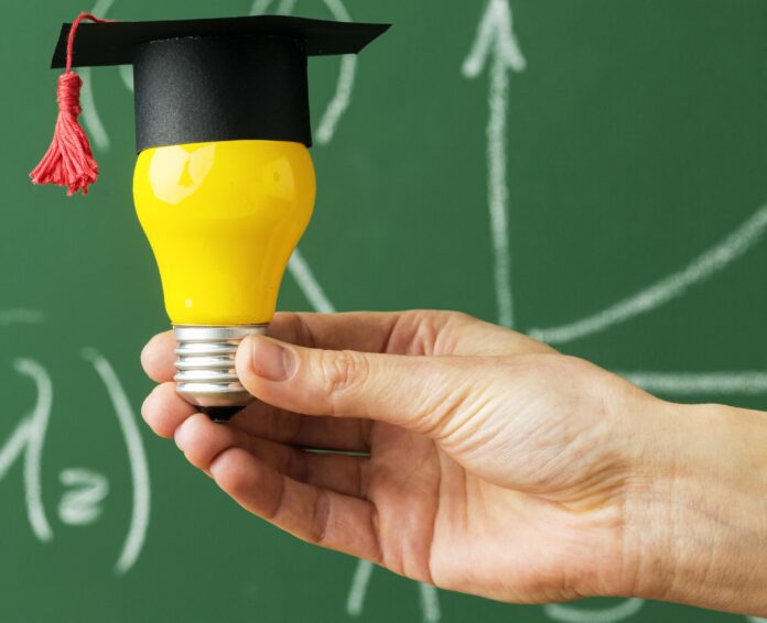 person-holding-lightbulb-with-academic-cap